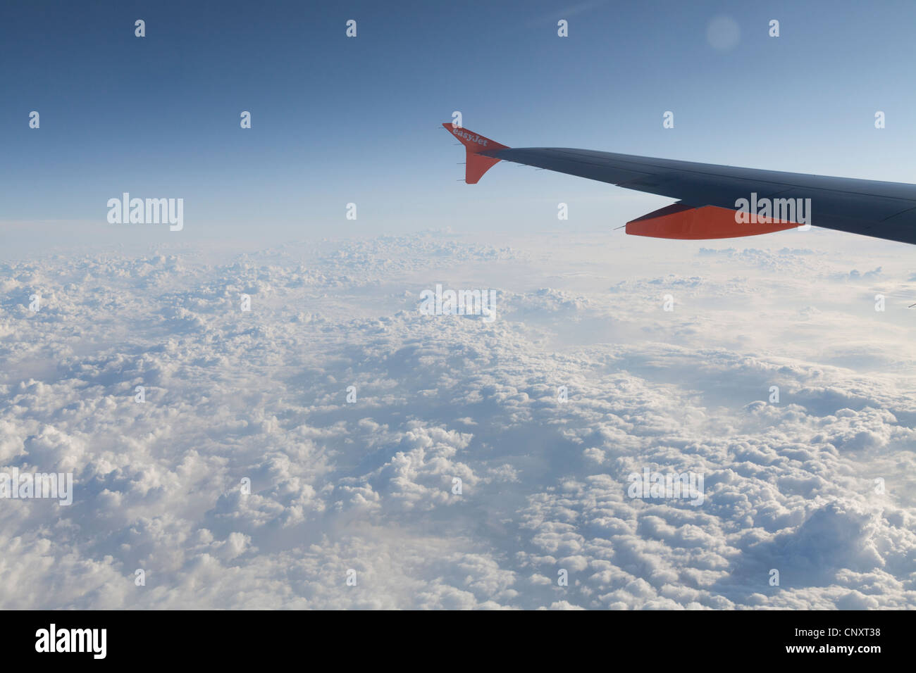 Easyjet ala coperta al di sopra delle nuvole e cielo blu Foto Stock
