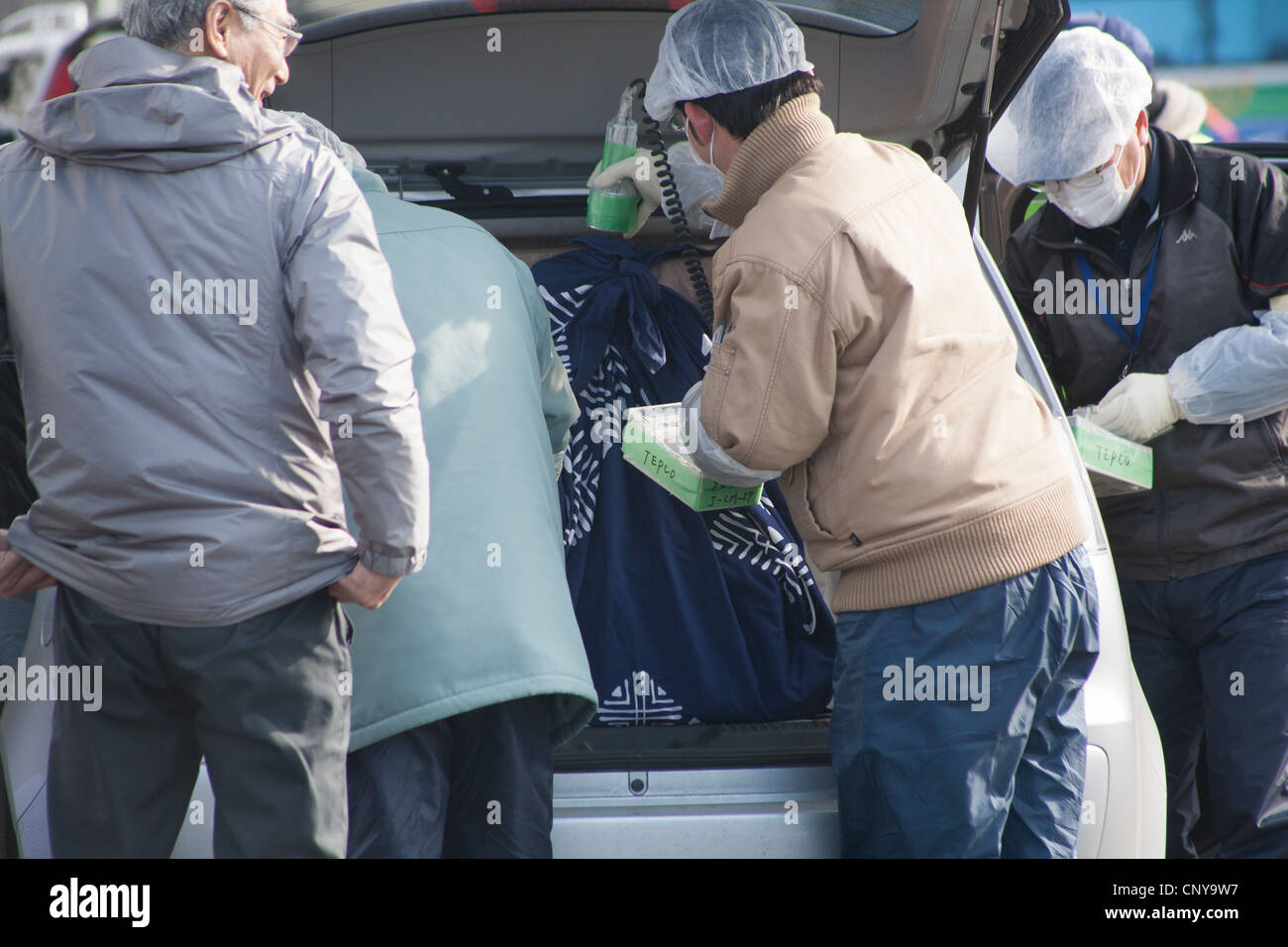 Residenti all'interno del 20km Fukushima exclsuion hanno fuso le loro auto controllato per verificare la presenza di contaminazione radioattiva, Minami-Soma Giappone Foto Stock