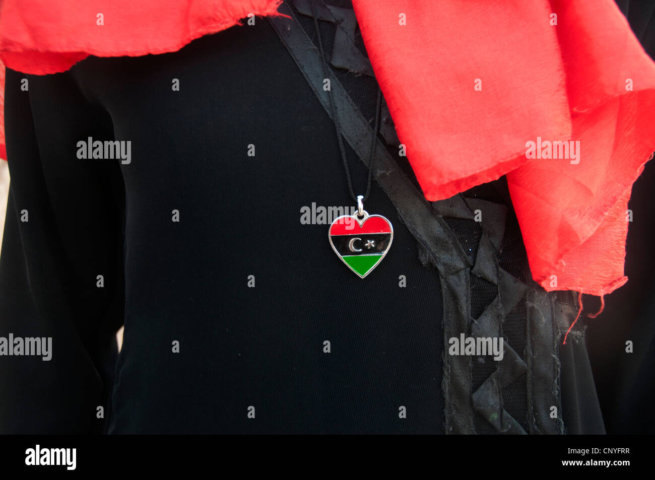 Libia Settembre 2011. Nalut. Close-up di a forma di cuore bandiera libica spilla indossata da giovane ragazza in un abito nero Foto Stock