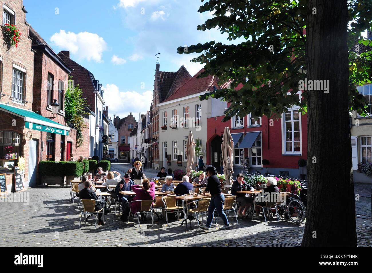 Belgio - Bruges - open air cafè nell'Walstraat area della città vecchia - la luminosa luce del sole - Blu cielo Foto Stock