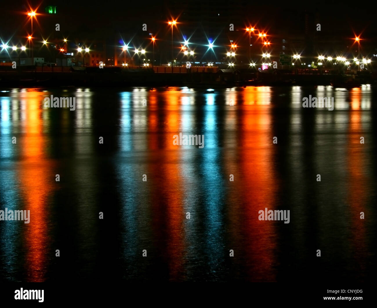 Città di notte con le luci riflesse in acqua Foto Stock