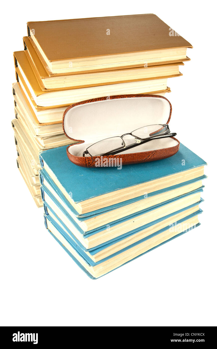 Pila di libri vecchi e bicchieri su sfondo bianco Foto Stock