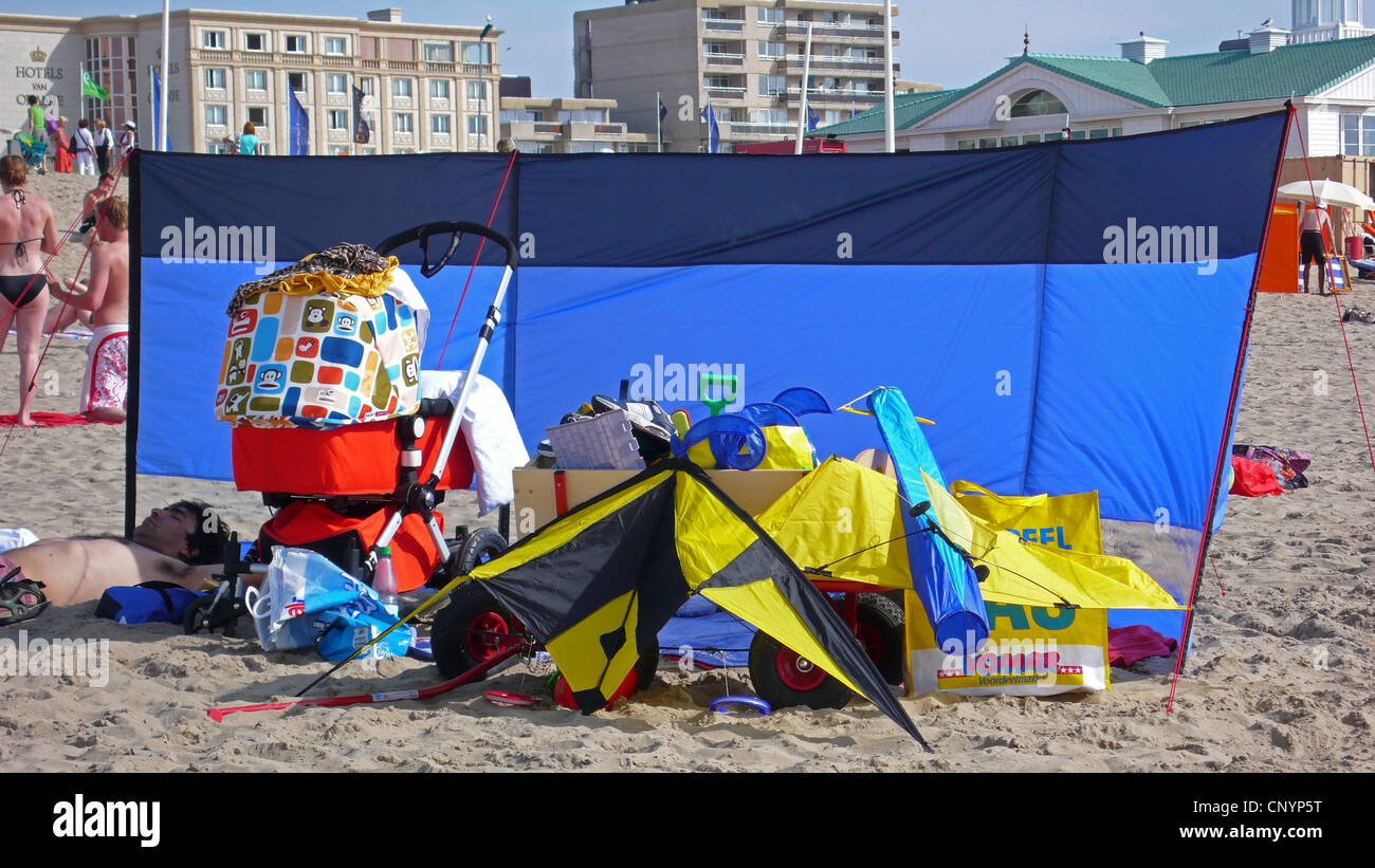 Luogo pieno di utensili da spiaggia a ridosso di una parete di frangivento a una spiaggia balneare Foto Stock