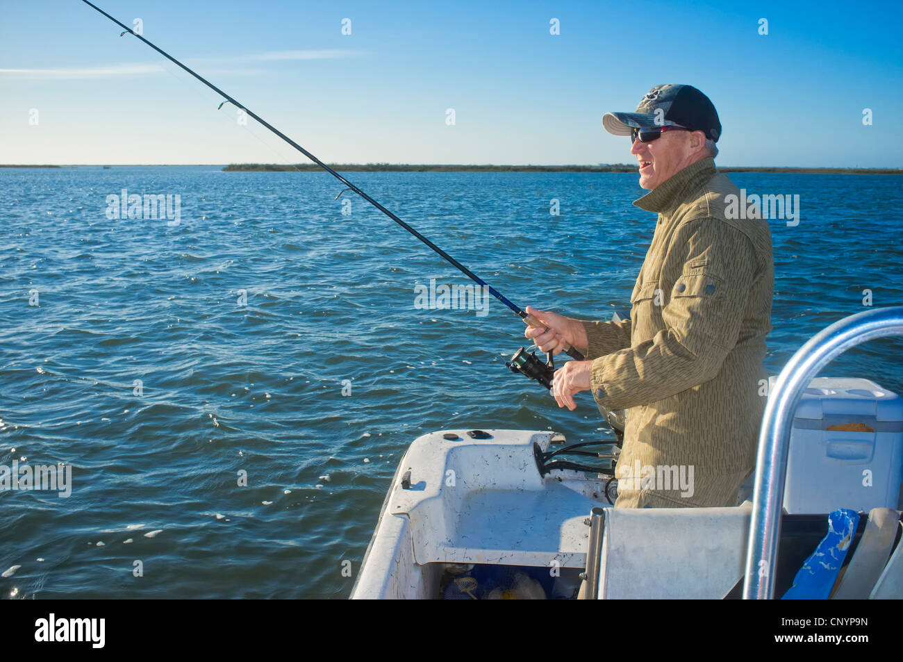 L'uomo la pesca dalla barca presso Texas Gulf Coast Foto Stock