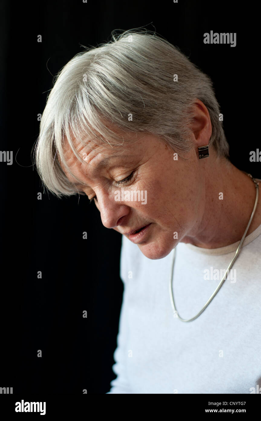 Donna di mezza età guardando giù wistfully Foto Stock