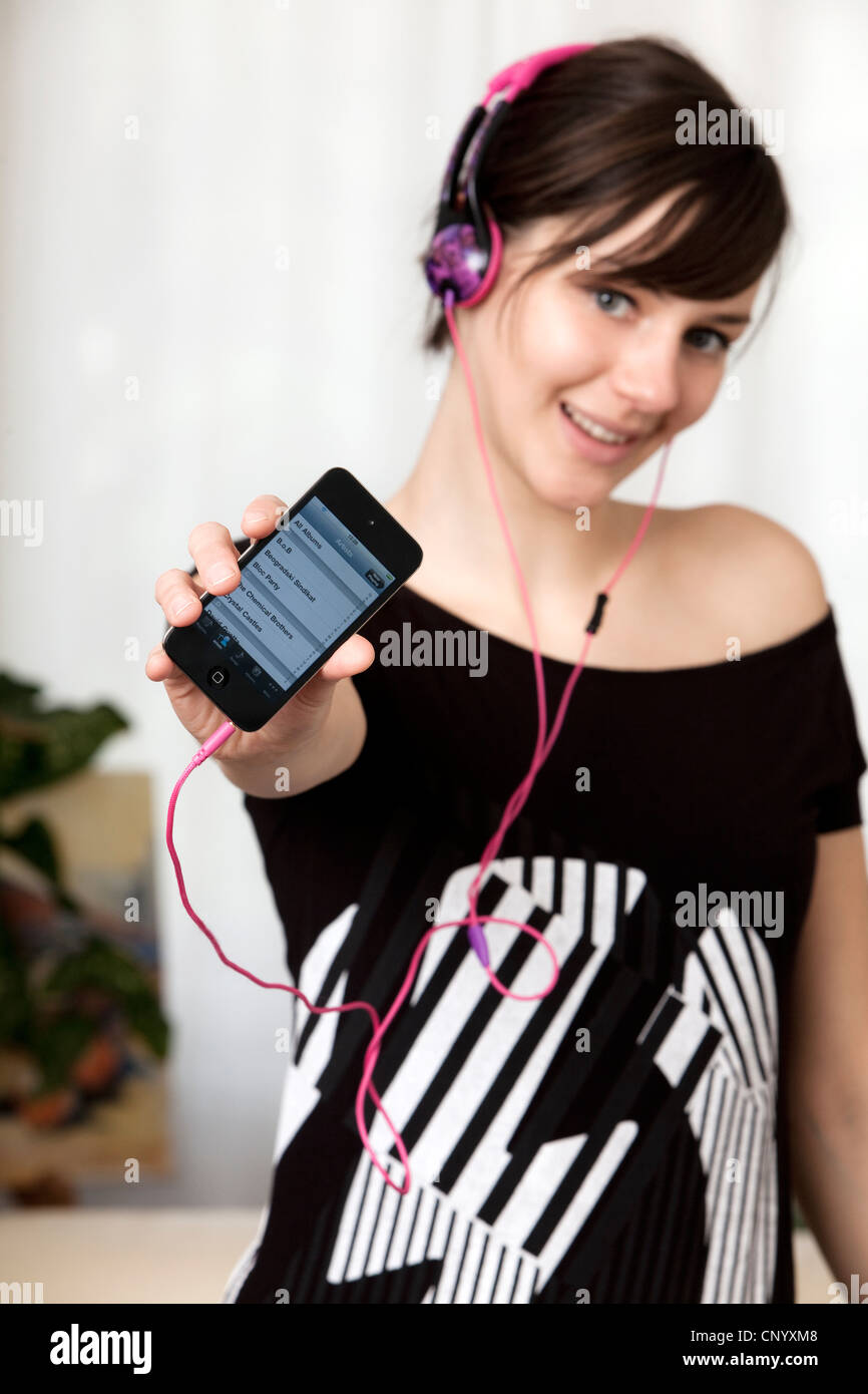 La ragazza con gli auricolari mostra un ipod Foto Stock