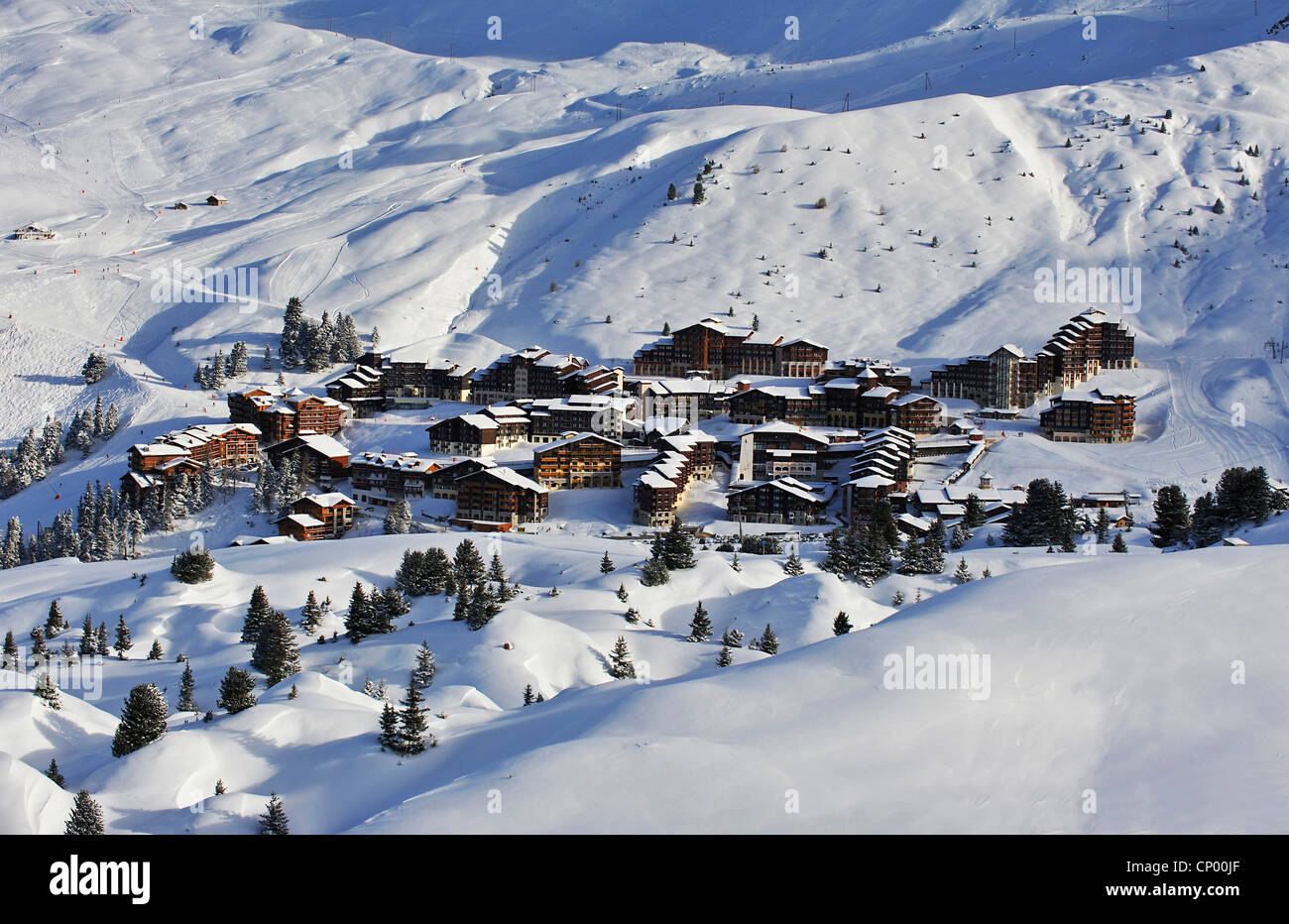 Snowbound ski resort sotto il sole visto da un pendio di montagna, Francia, Savoie, Belle Plagne Foto Stock