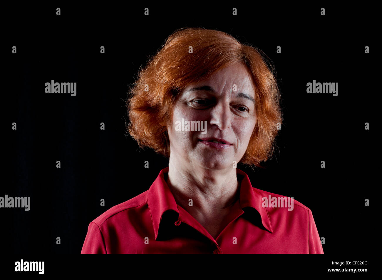 Donna di mezza età in camicia rossa guardando pensieroso Foto Stock