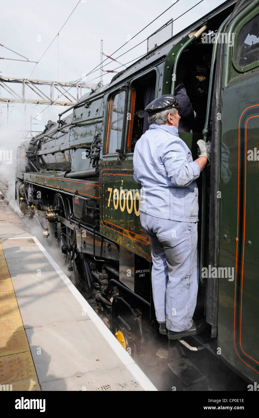 Britannia 70000 locomotiva a vapore costruita nel 1951 sulla carta eseguire con autista circa per tornare al pavimento dopo un rifornimento acqua Foto Stock