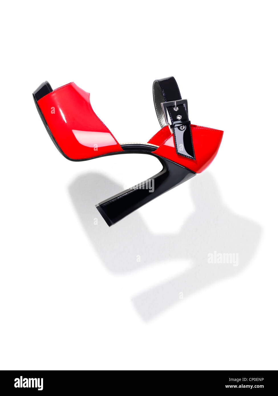 Rosso alla moda nera con tacco alto il pattino della piattaforma a cadere attraverso l'aria isolata su sfondo bianco Foto Stock