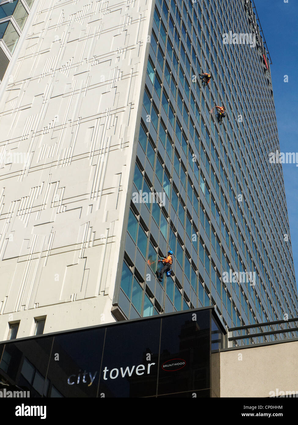 Tre detergenti per finestre al di fuori della città Torre in Manchester REGNO UNITO Foto Stock