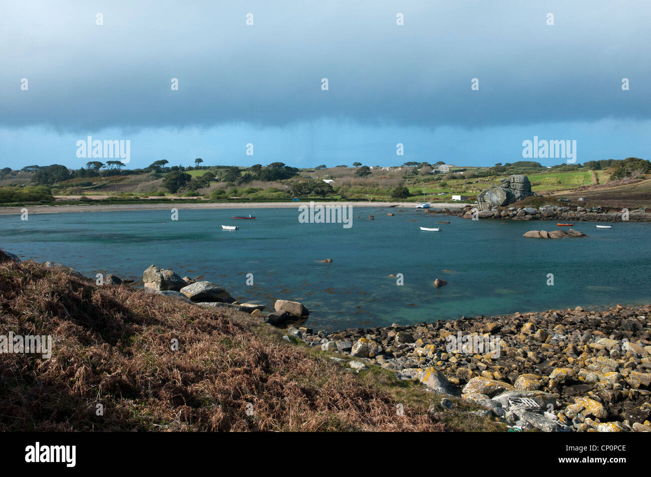 Vista di Porth Hellick sulla spiaggia di St Mary's sulle Isole Scilly con una barca ormeggiata nella baia Foto Stock