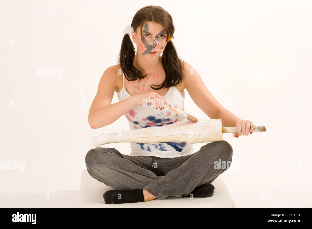 Giovane donna la verniciatura con vernice sul suo viso e mani Foto Stock