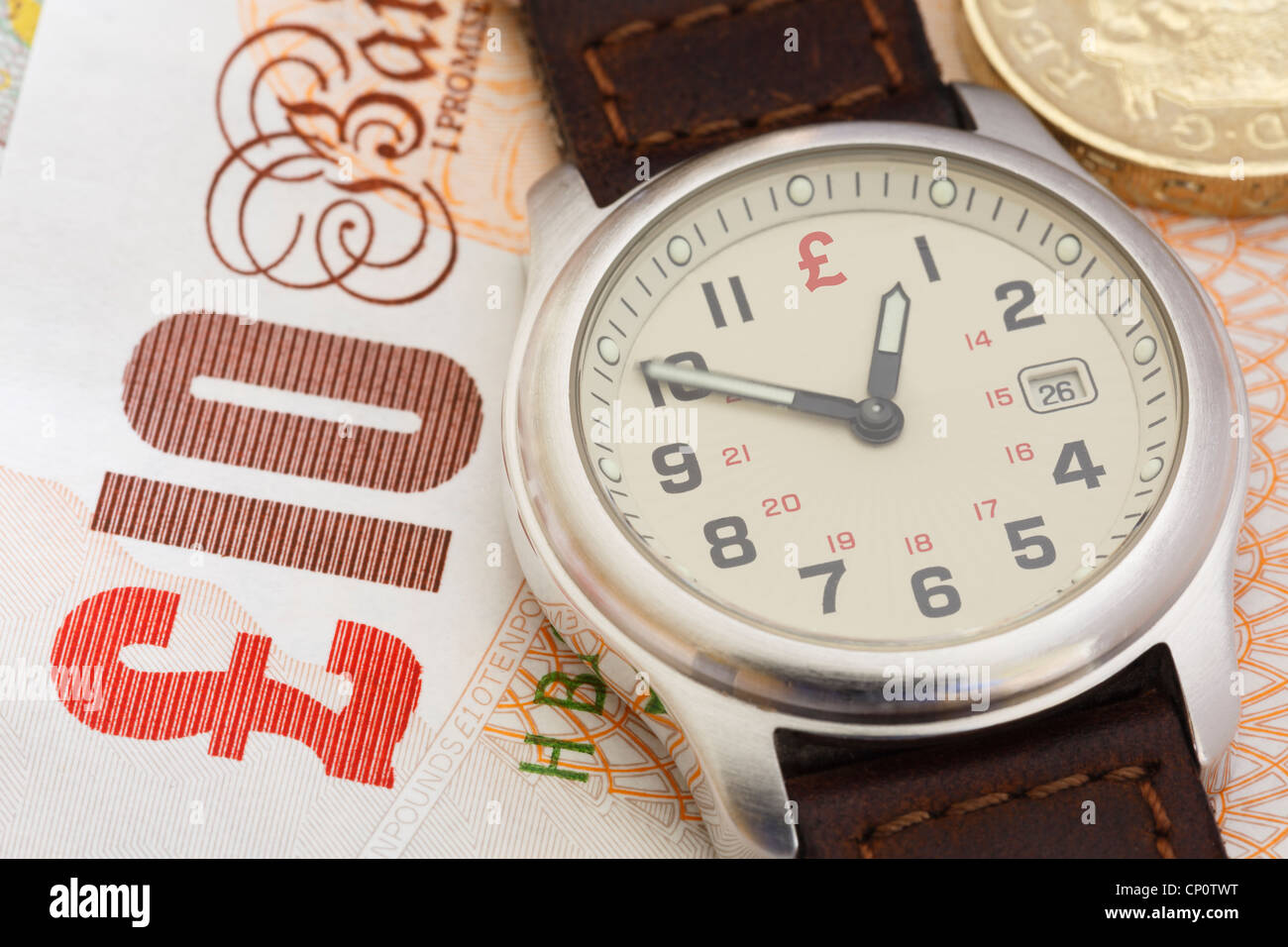 Orologio da polso orologio su una decina di Sterling Pound nota e una libbra di moneta per illustrare il concetto finanziario il tempo è denaro nel business. Inghilterra Regno Unito Gran Bretagna Foto Stock