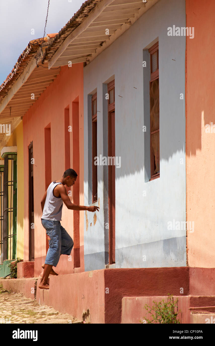 La vita quotidiana a Cuba - uomo cubano salire le scale per entrare in casa a Trinidad, Cuba Foto Stock