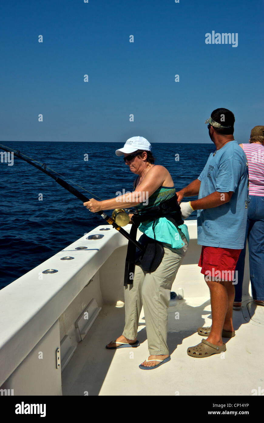 Donna con cinghia di combattimento per tenere la canna da pesca giocare in grandi deepsea offshore gamefish Golfo del Messico Foto Stock