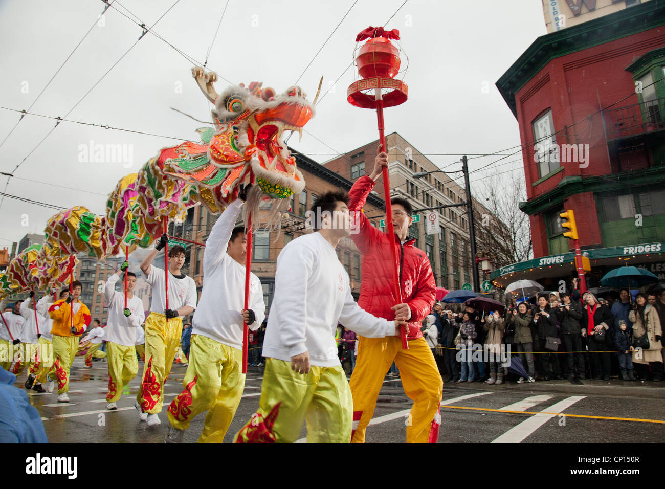 Gli uomini corrono in unisono con una lunga discesa dragon Pender Street a Vancouver China Town di durante il 2012 il nuovo anno lunare. Foto Stock