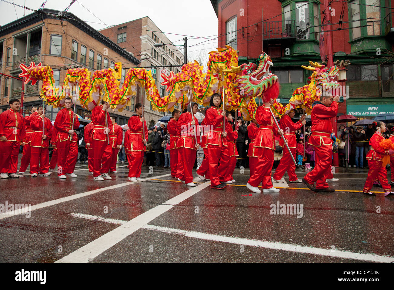 I partecipanti del 2012 Anno Nuovo Cinese parade trasportare lungo i draghi in giù per le strade di Vancouver China Town. Foto Stock