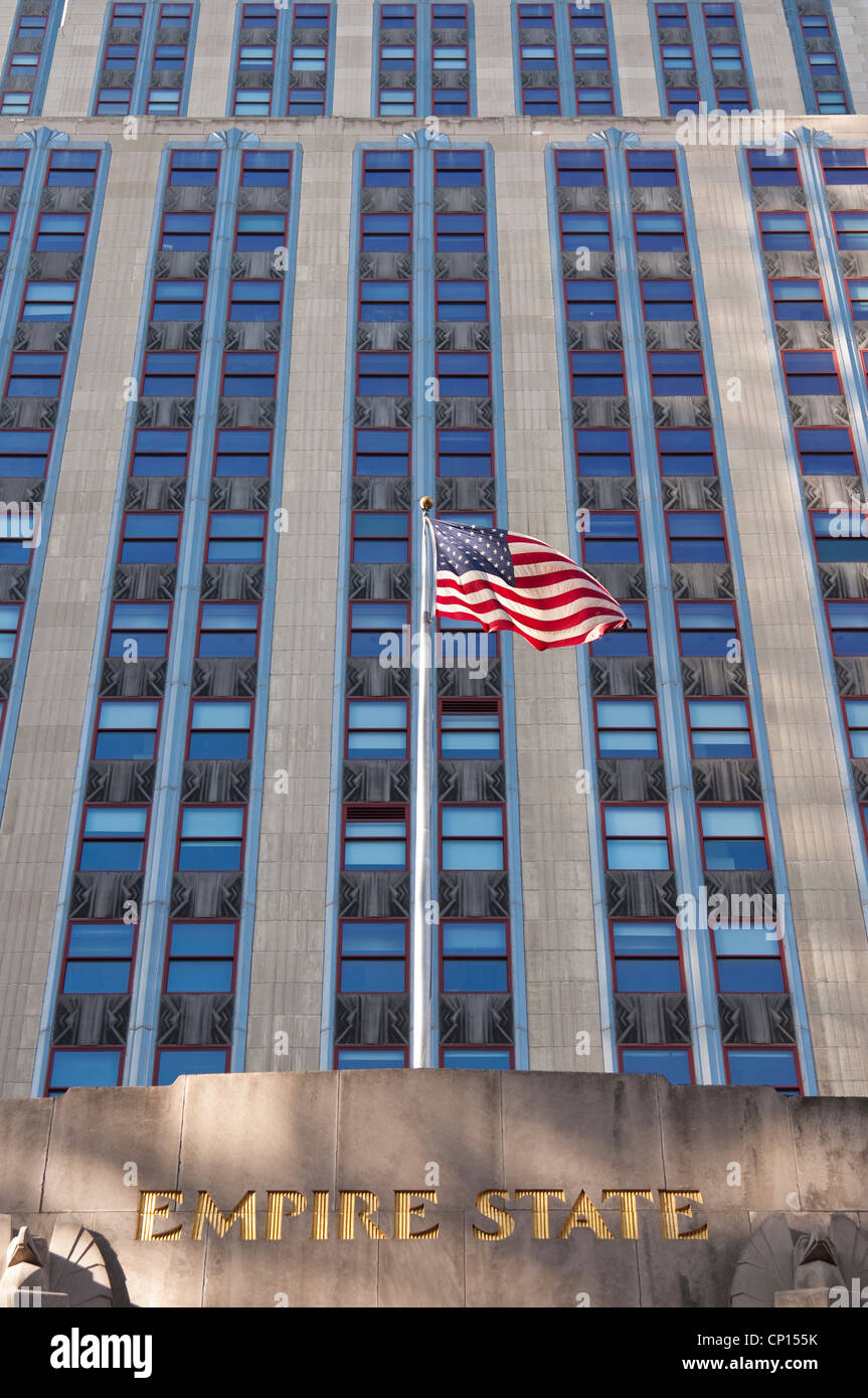 L'Empire State Building, con le stelle e strisce [americana bandiera nazionale] battenti nel vento. La città di New York, Stati Uniti d'America. Foto Stock