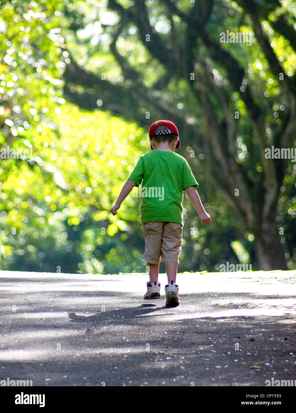 Quattro anni ragazzo autistico di passeggiate con i pugni serrata, una strada a Waimea Valley verso le cascate. Foto Stock