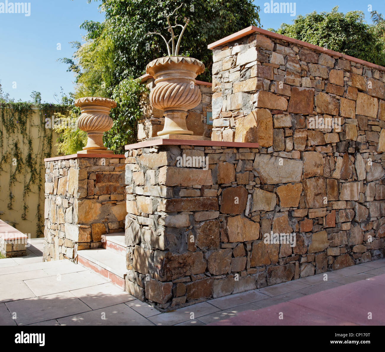 Generico con giardino di pietra scolpita vasi per piante amd randon pietra locale parete masoned Foto Stock