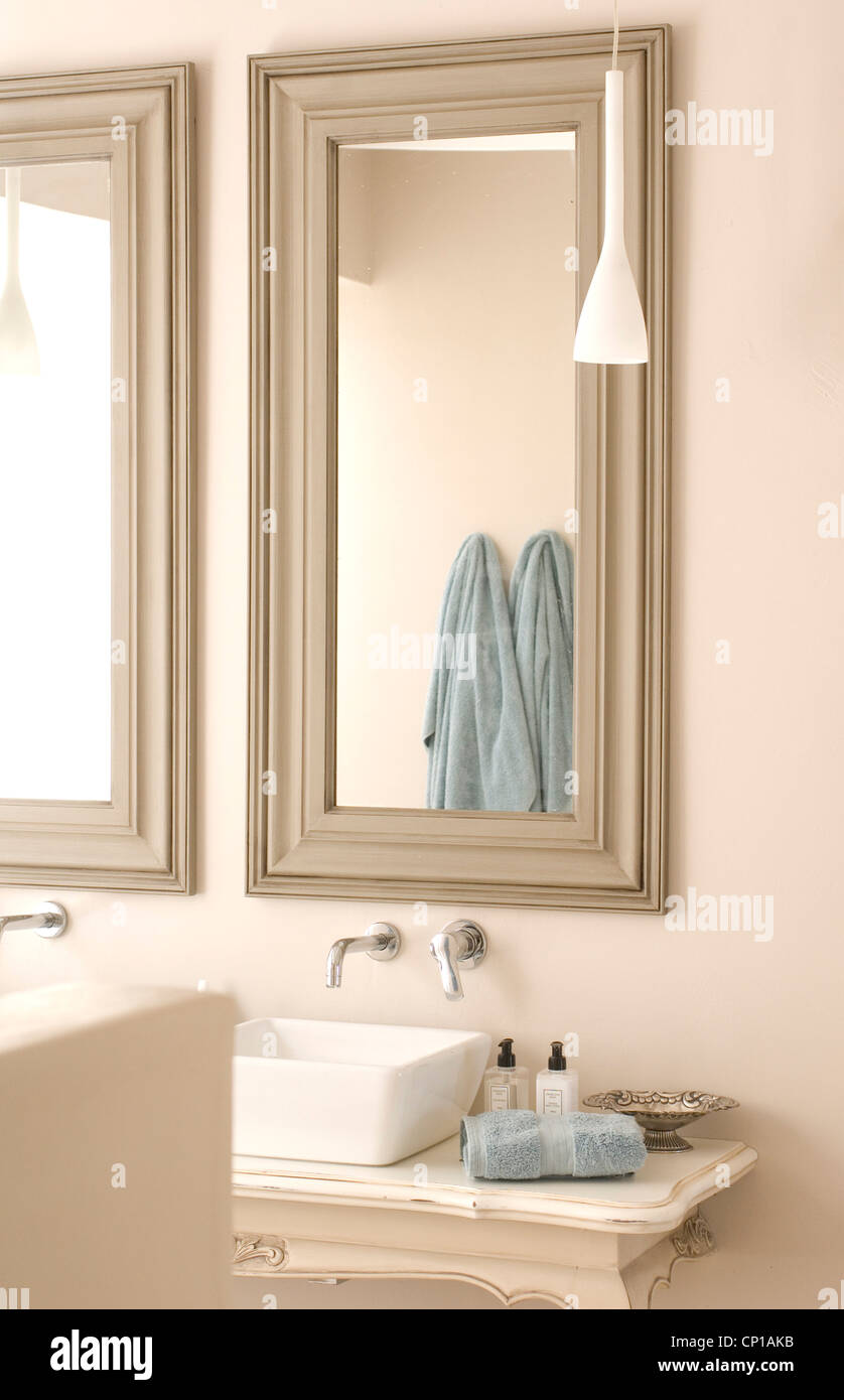 Luce asciugamani blu riflessa in specchio sopra è stata bacino. Foto Stock