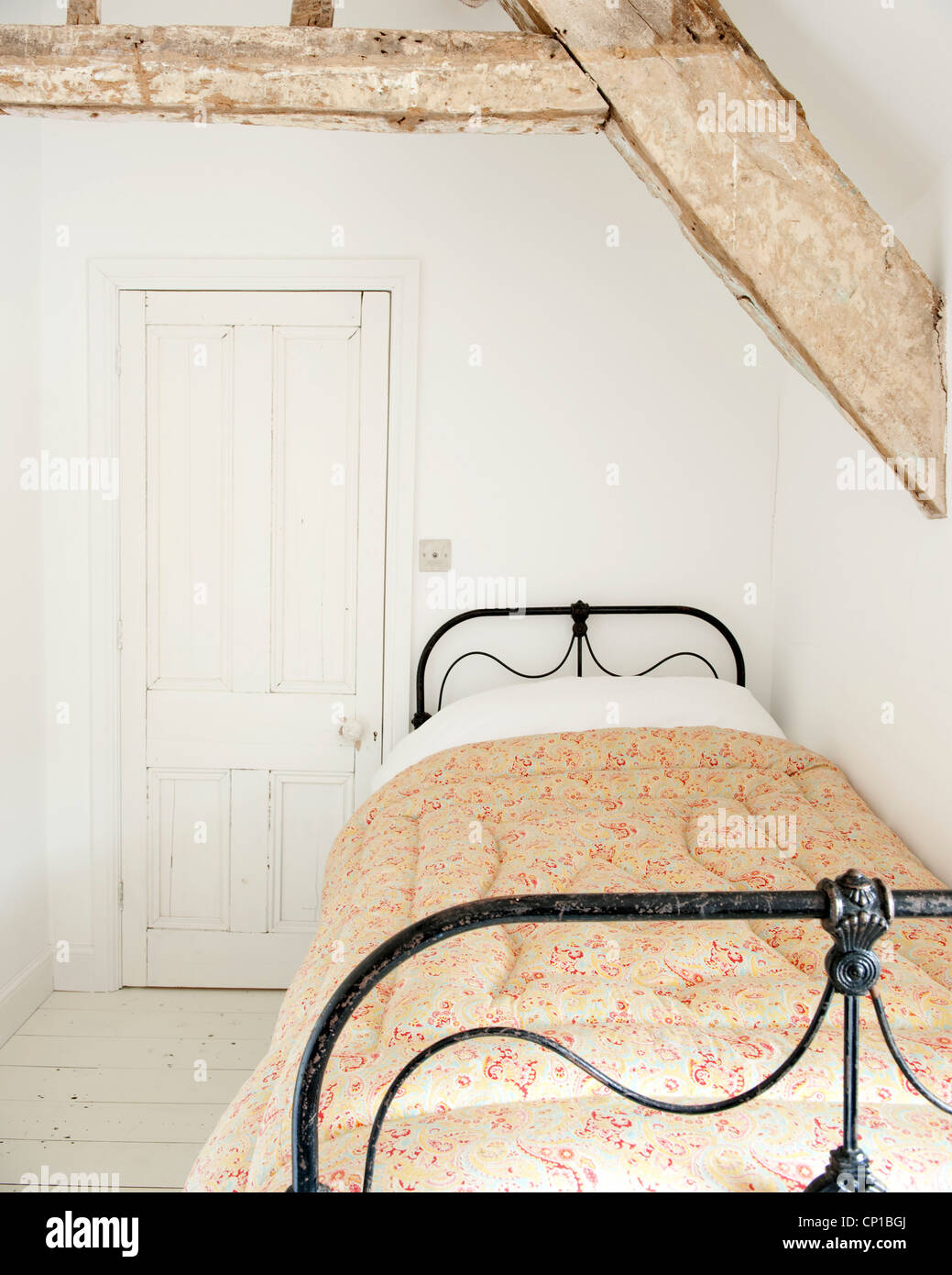 Un letto singolo con travi in camera mansardata, Orchard Cottage, UK. Foto Stock