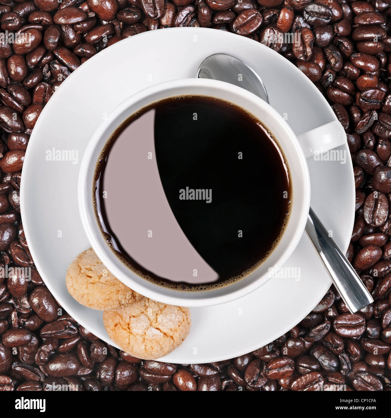 Foto aerea di una tazza di caffè con amaretti sul lato con un background di freschi fagioli arrosto Foto Stock