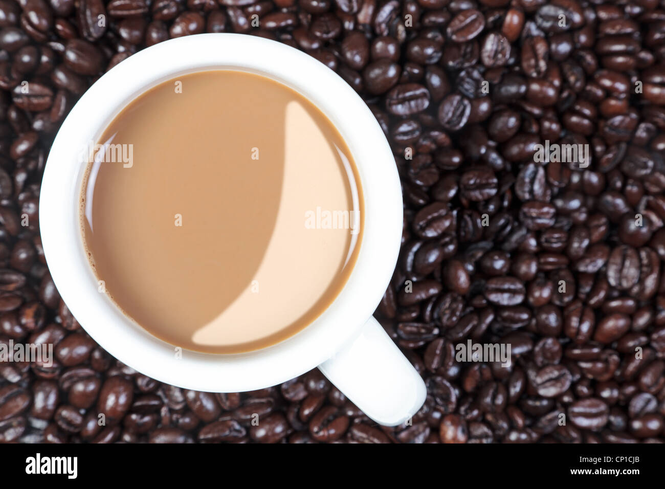 Foto aerea di una tazza piena di caffè caldo su una miscela di arabica e robusta i chicchi di caffè. Foto Stock