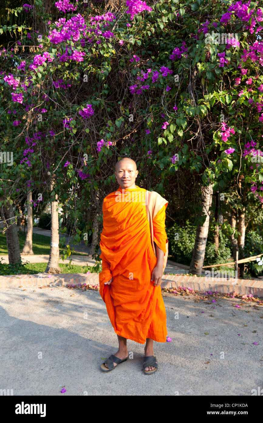 Una fotografia di un caldo monaco Lao in posa di fronte a una bouganville, in Luang Prabang (Laos). Photographie d'onu moine Laotien. Foto Stock