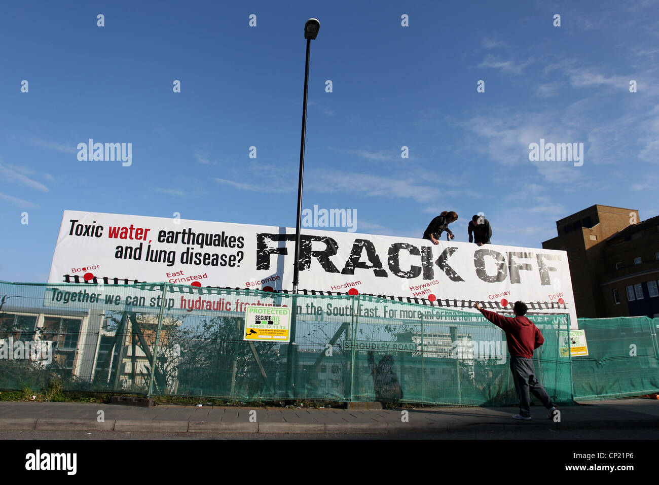 I manifestanti foto di installazione di un gigante di anti-fracking poster fuori la stazione del treno, Brighton East Sussex, Regno Unito. Foto Stock