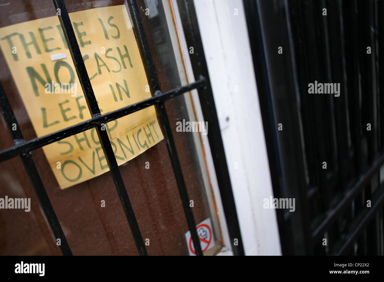 Segno di sicurezza e griglia metallica in negozio porta. Foto Stock