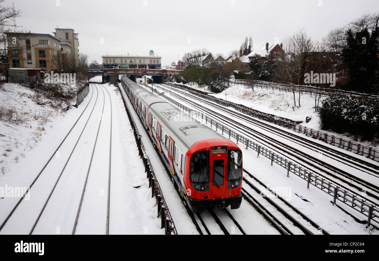 Linea metropolitana treno tubo rendendo il suo modo a Londra durante la neve Foto Stock
