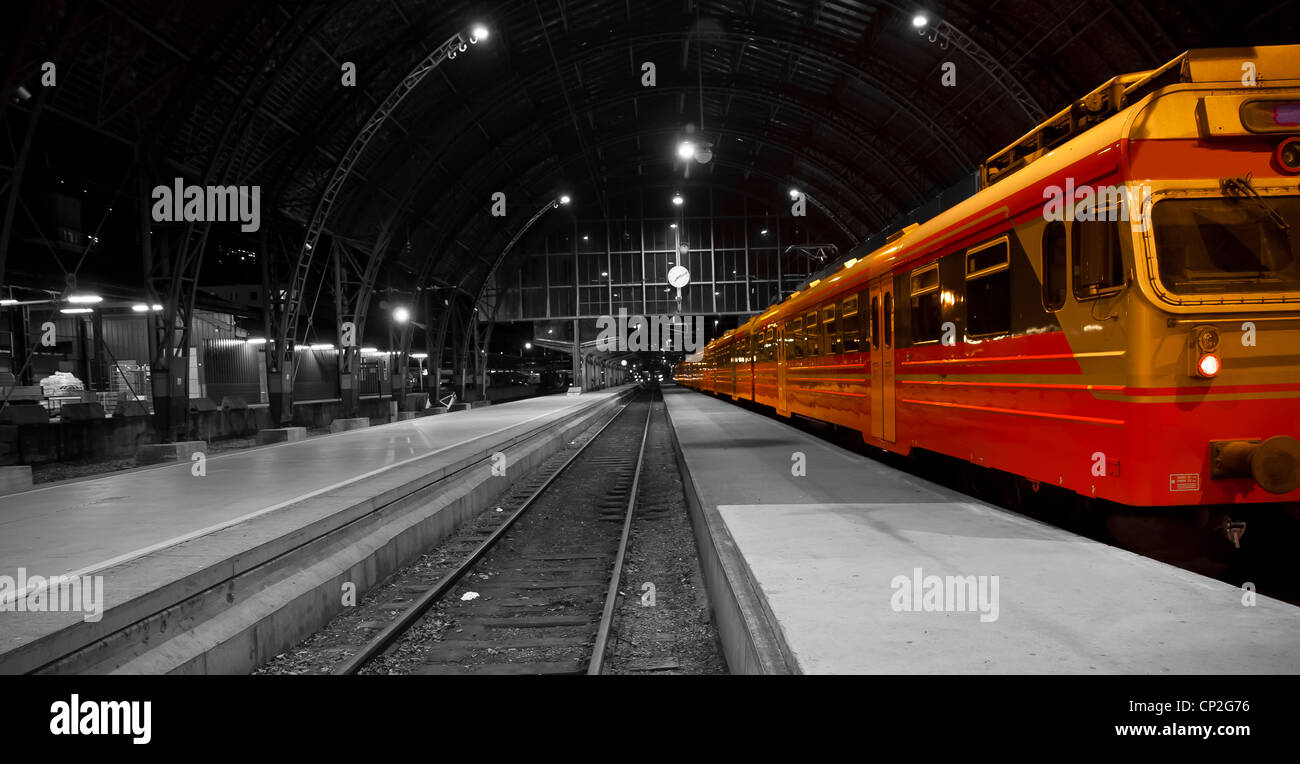 Una foto di un treno in una stazione ferroviaria, bianco nero foto.Con il treno a colori Foto Stock
