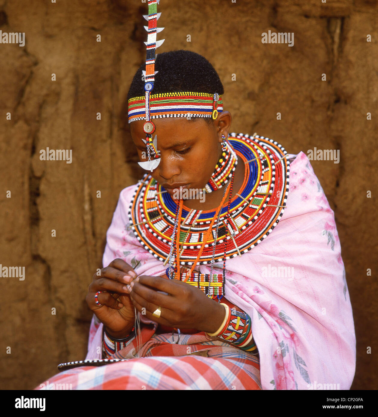 Maasai donna in abiti tribali, il Masai Mara National Reserve, Narok County, Repubblica del Kenya Foto Stock