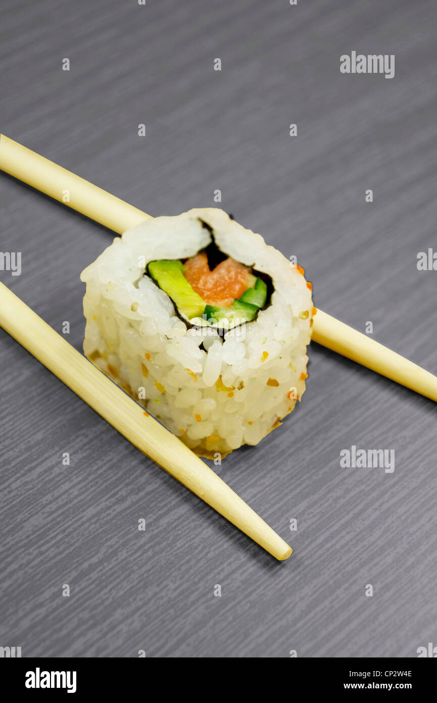 I sushi giapponesi La cucina e bastoni isolato nero sul pannello di legno Foto Stock