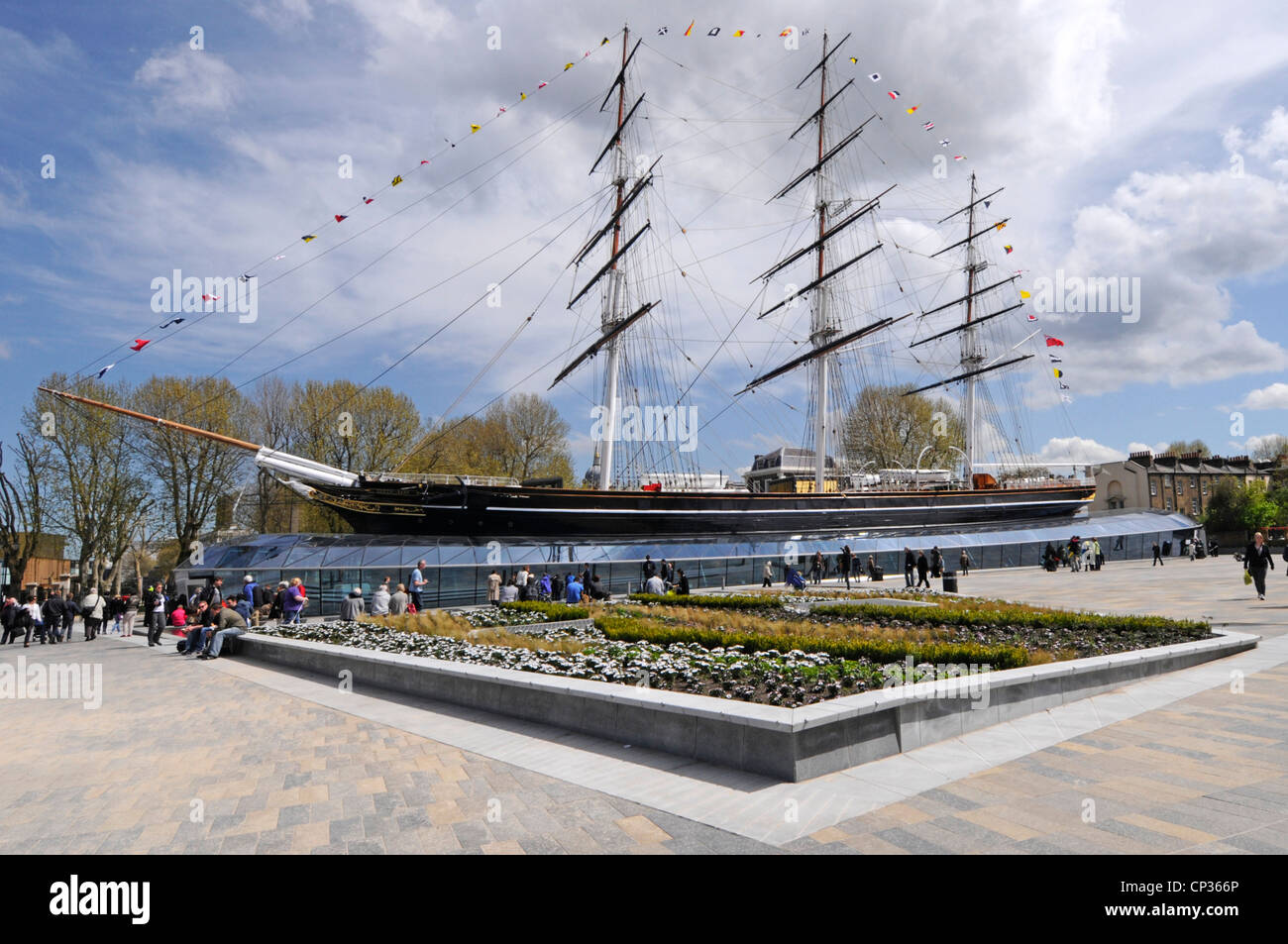Le persone che visitano lo spazio aperto lastricato presso lo storico tè Cutty Sark la nave clipper è aperta ai visitatori a bordo dopo il restauro di Greenwich London Inghilterra Regno Unito Foto Stock