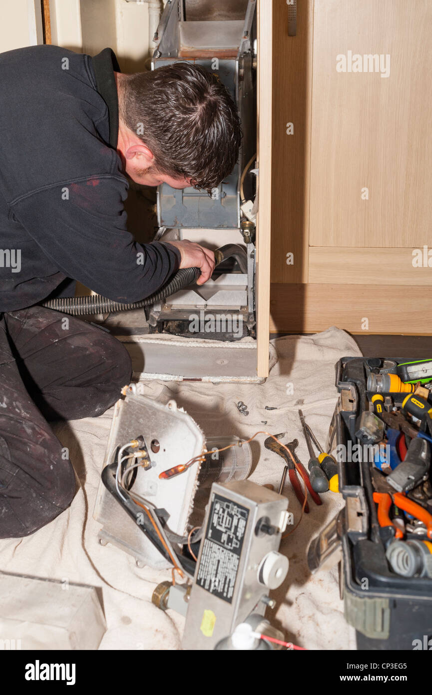 Un idraulico e ingegnere di riscaldamento la manutenzione di una caldaia a gas nel Regno Unito Foto Stock