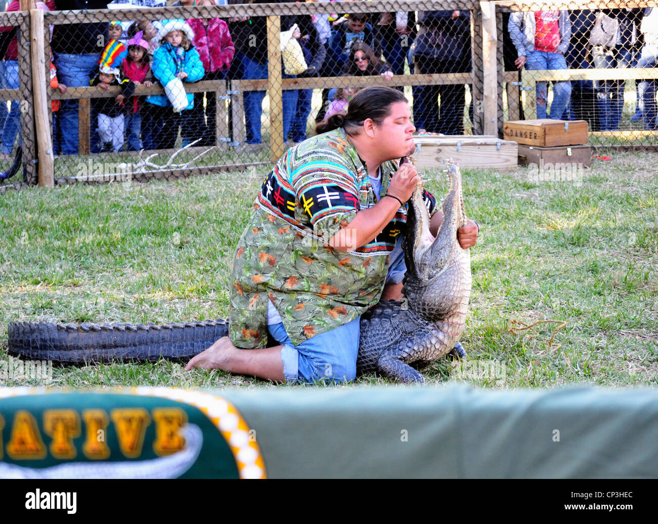 Wrestler di alligatore tocca il suo mento per il muso di un alligatore all'annuale Ormond Beach Native American Festival Foto Stock