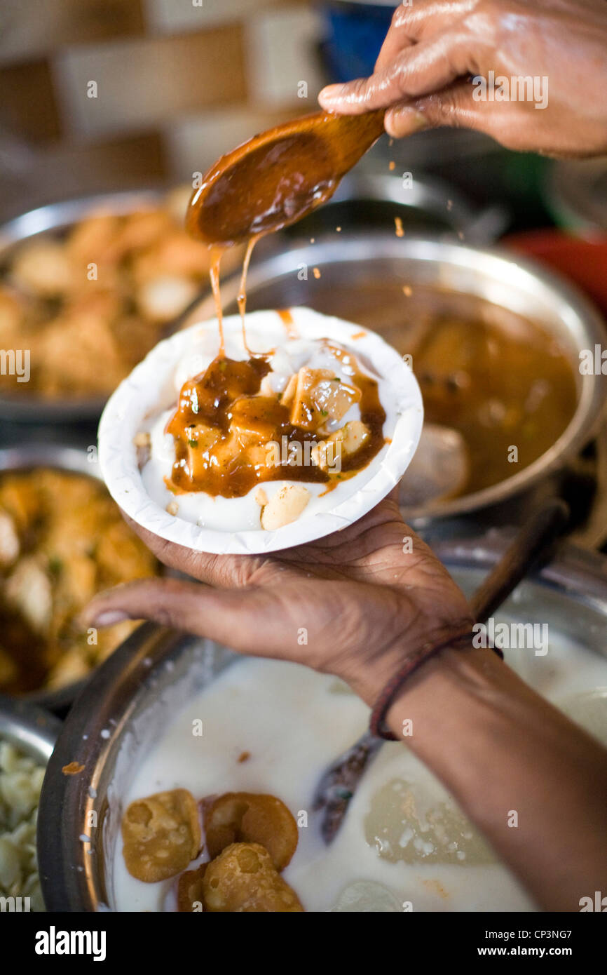 Un uomo fa di diversi tipi di chat (street food snack) all'Ashok Chat Corner in Chawri Bazaar, la Vecchia Delhi India Foto Stock