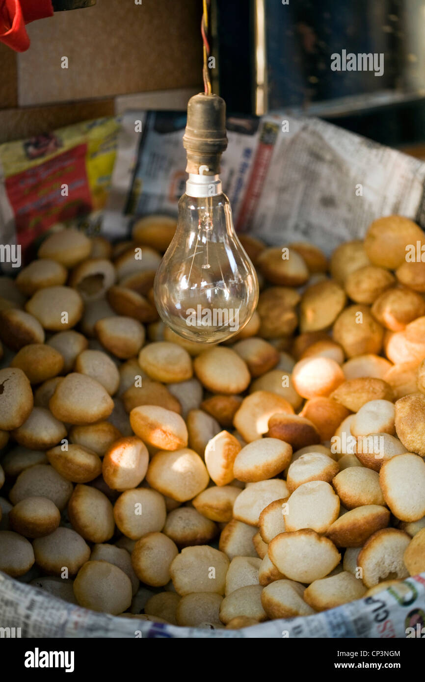 Gols o piccoli pani cava in attesa di essere riempito con liquido piccante per rendere golgappas - spuntini al Ashok Chat Corner, Delhi Foto Stock