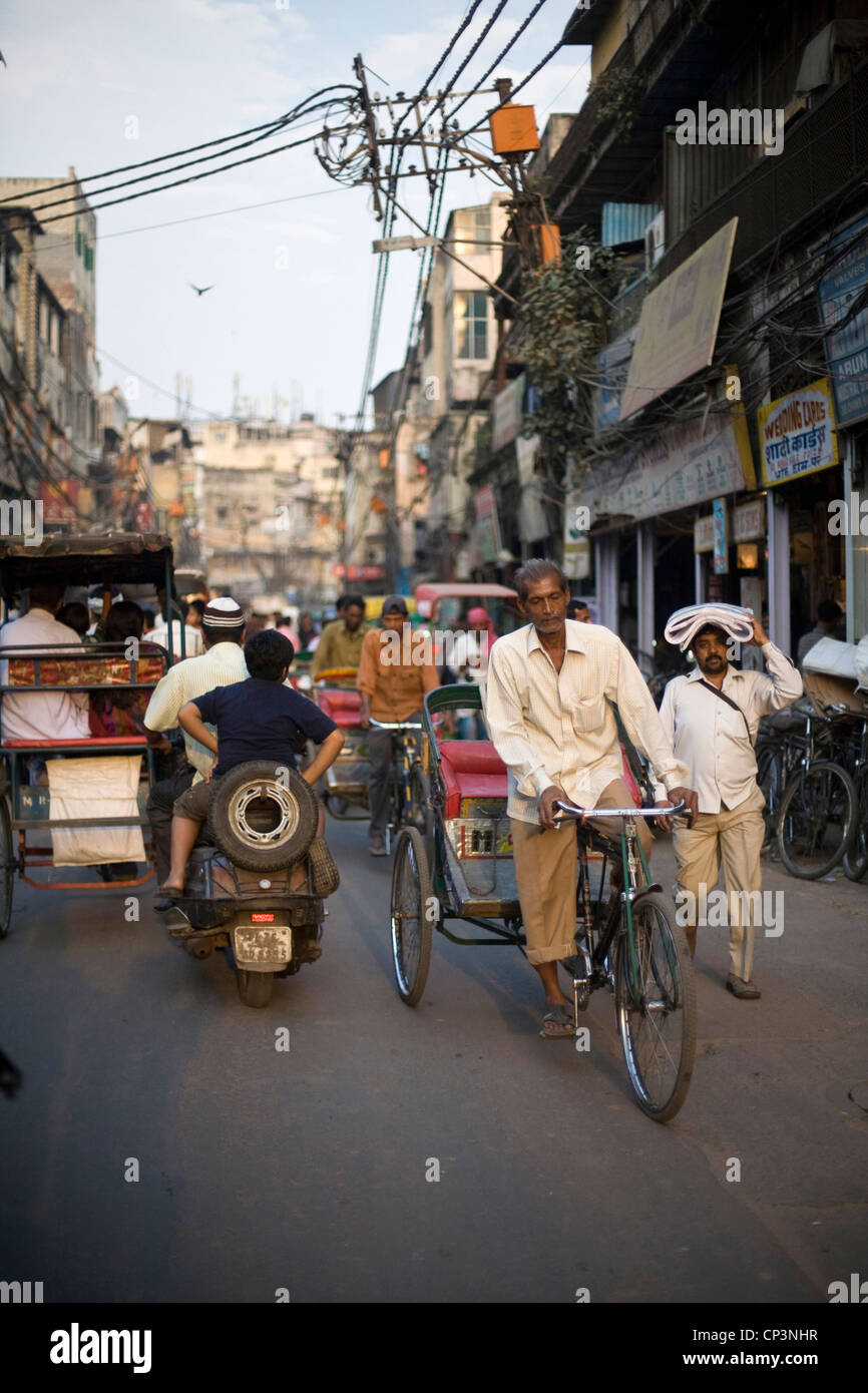 Un uomo peddles il suo ciclo rickshaw sulle strade di Chawri Bazaar, la Vecchia Delhi, India Foto Stock