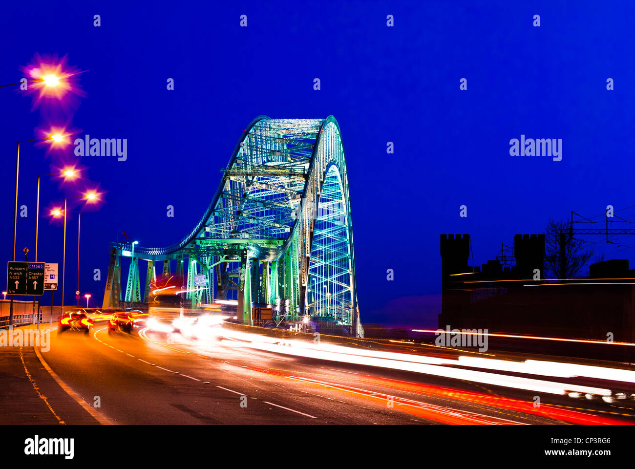 Auto semaforo percorsi che attraversano il Giubileo d'argento Bridge, Runcorn di notte, Cheshire, Inghilterra, Regno Unito Foto Stock