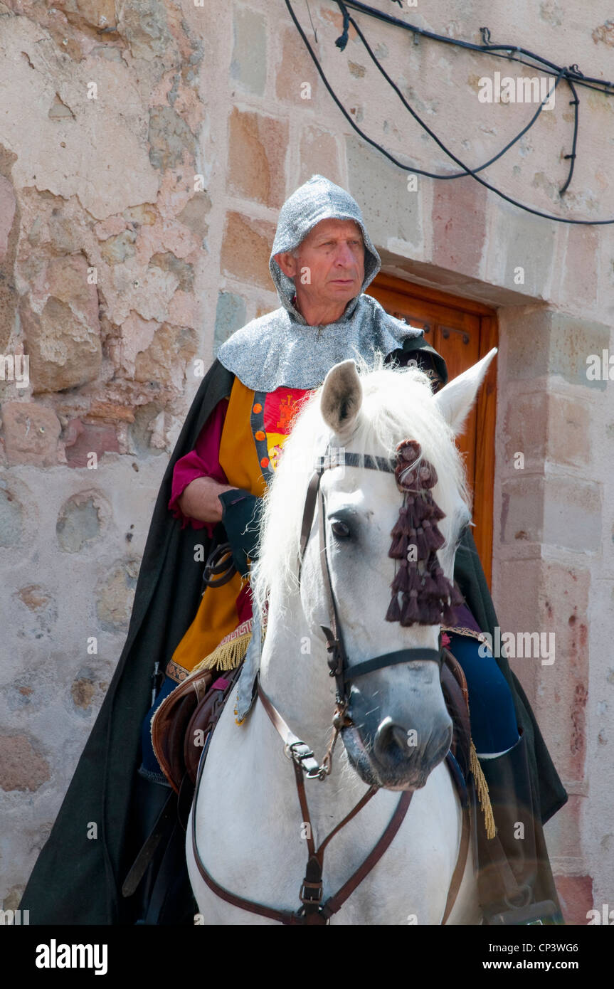 Uomo che indossa abiti medievali, a cavallo. Sigüenza, provincia di Guadalajara, Castilla La Mancha, in Spagna. Foto Stock