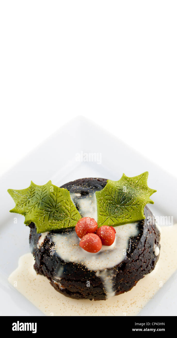 Pudding natalizio con crema, Glitter e commestibile Holly. Foto Stock