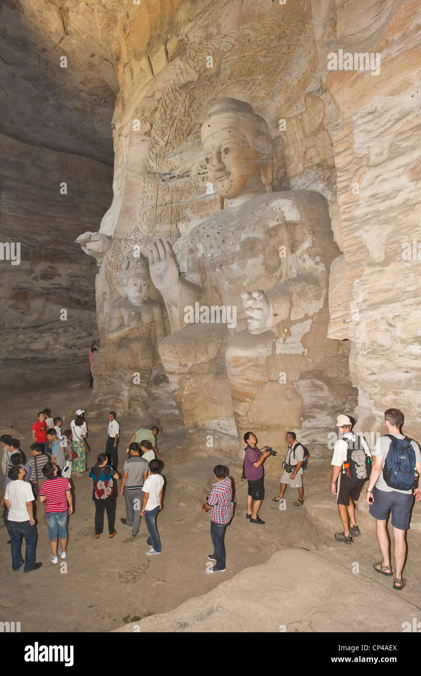 I turisti all'interno del Lin Yan Grotta Grotta (n3) ammirando il bodhisattva (Buddah statue) presso le grotte di Yungang. Foto Stock