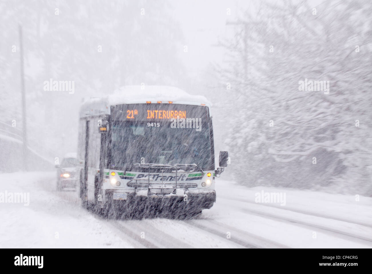 Città bus di transito su strada rurale durante l'inverno blizzard-Victoria, British Columbia, Canada. Foto Stock