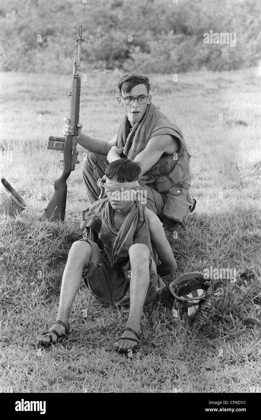 Guerra del Vietnam. Un US Marine protezioni corporali di un legato, bendati Nord soldato vietnamita ha catturato dieci miglia a nord-est di un Foto Stock