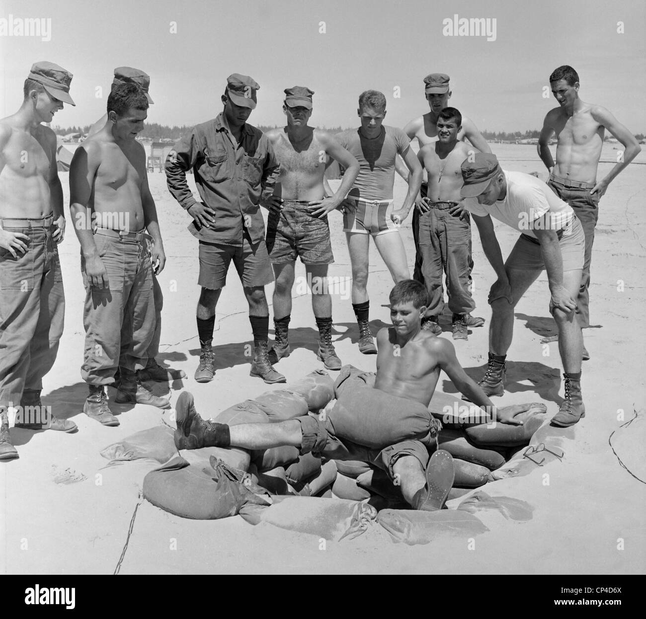 Guerra del Vietnam. US marina il Tenente incarica i soldati in un estremo della gamba e stomaco esercizio muscolare eseguito su una sandbagged Foto Stock