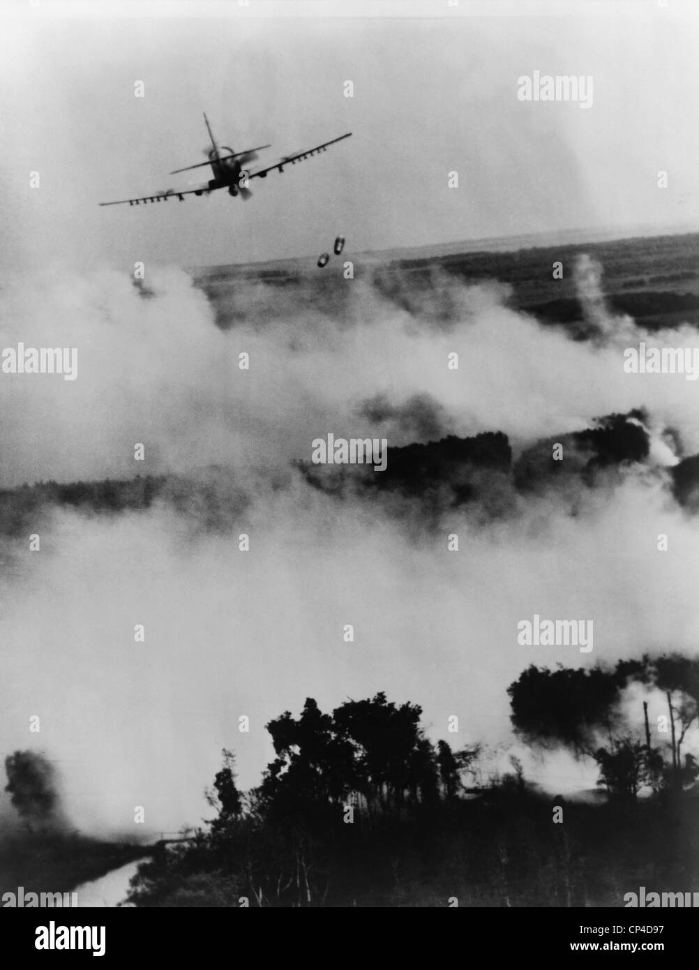 Guerra del Vietnam bombardamenti. Due bombe cadono da un vietnamita Air Force A-1E Skyraider su un ardente Viet Cong nascondiglio vicino a Cantho, Foto Stock